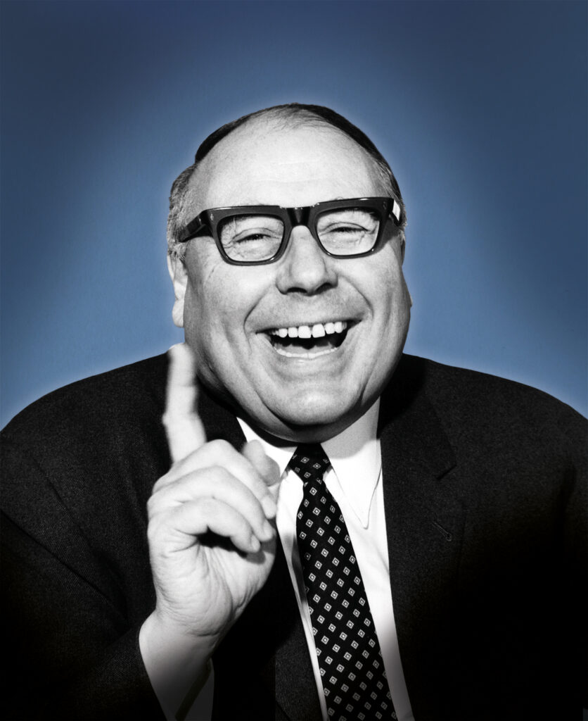 Heinz lachend mit erhobenem Zeigefinger